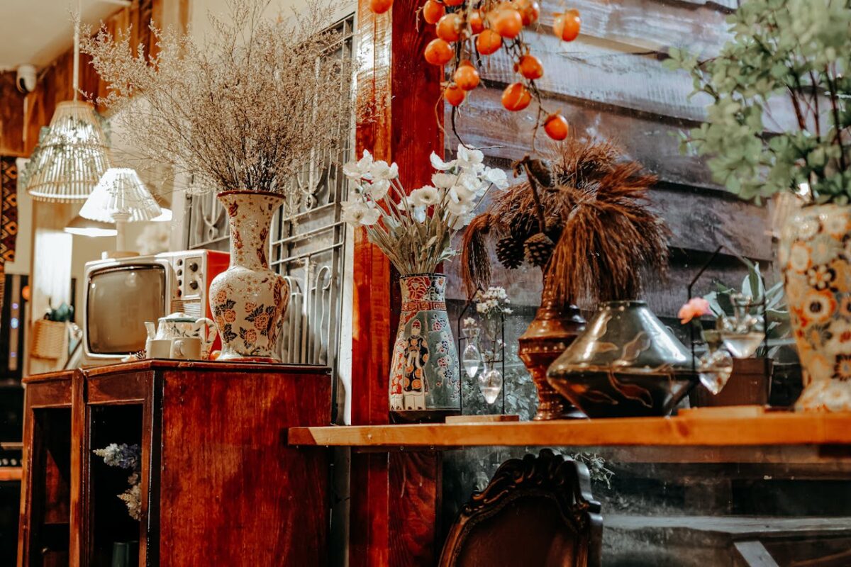who-we-are Cozy rustic interior featuring vintage decor, floral vases, and antique TV.