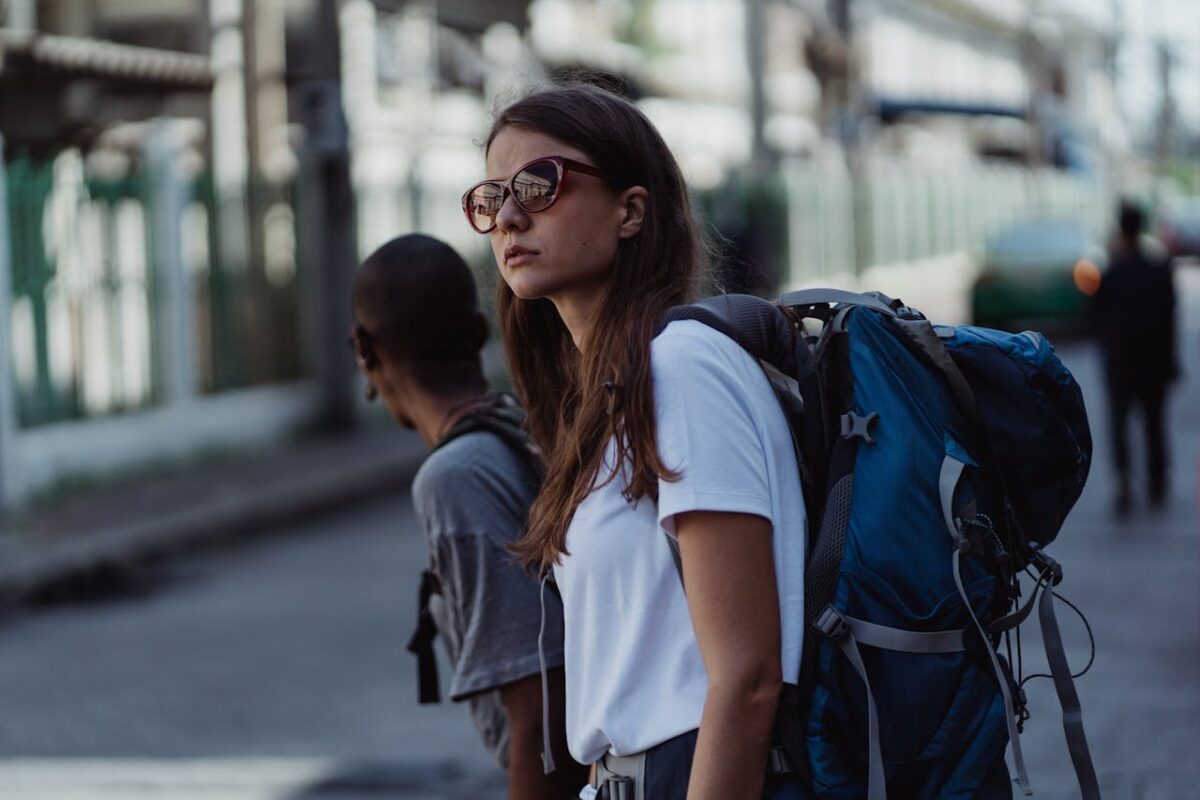 services-03 A young woman with a backpack explores the city, embracing urban travel and adventure.